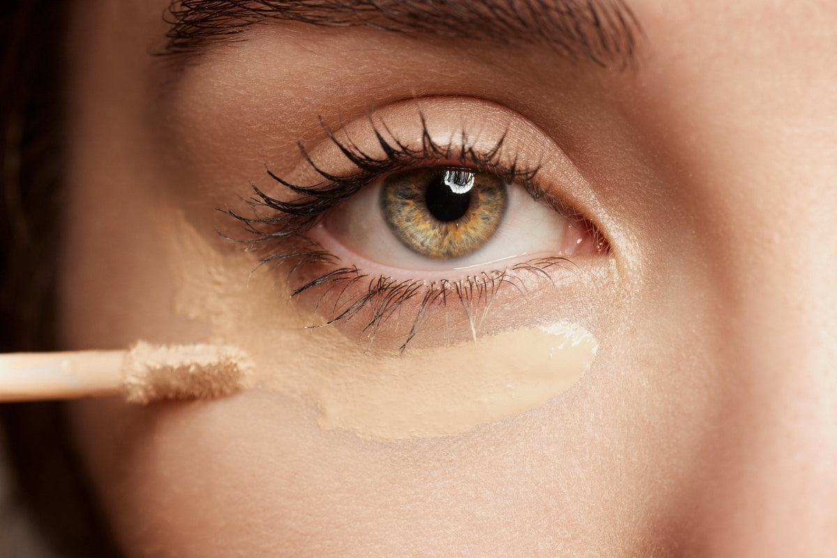 Close-up of concealer being blended under a woman's eye