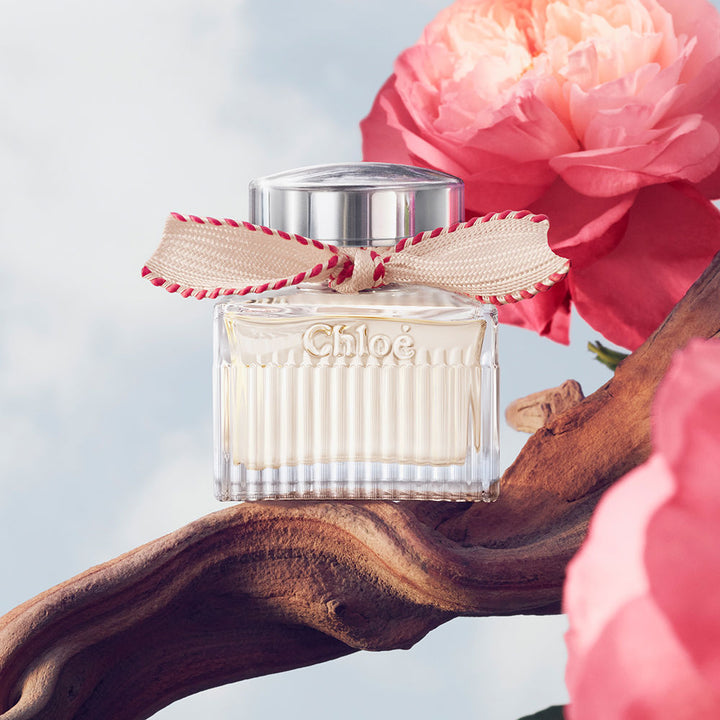 50 ml clear glass perfume bottle with beige ribbon and silver cap, floral scent