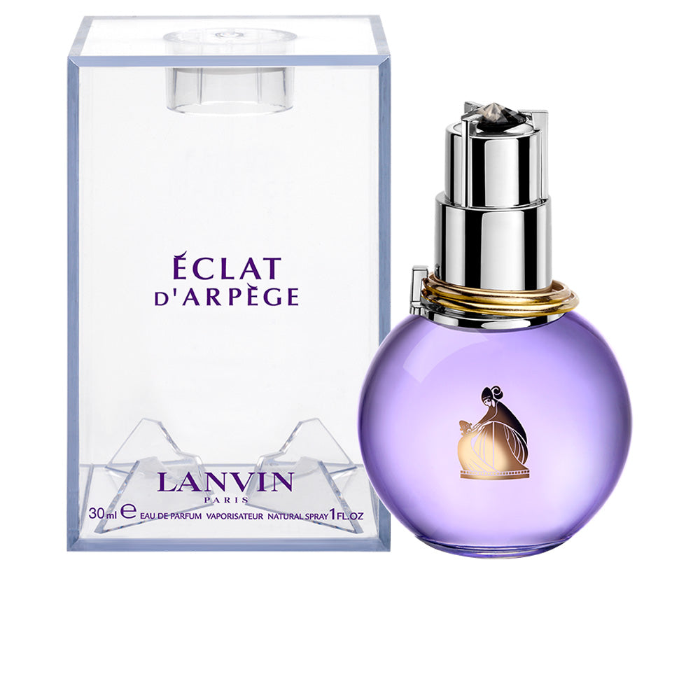 Lanvin Light purple glass round perfume bottle with silver cap, gold rings at neck, transparent box nearby.