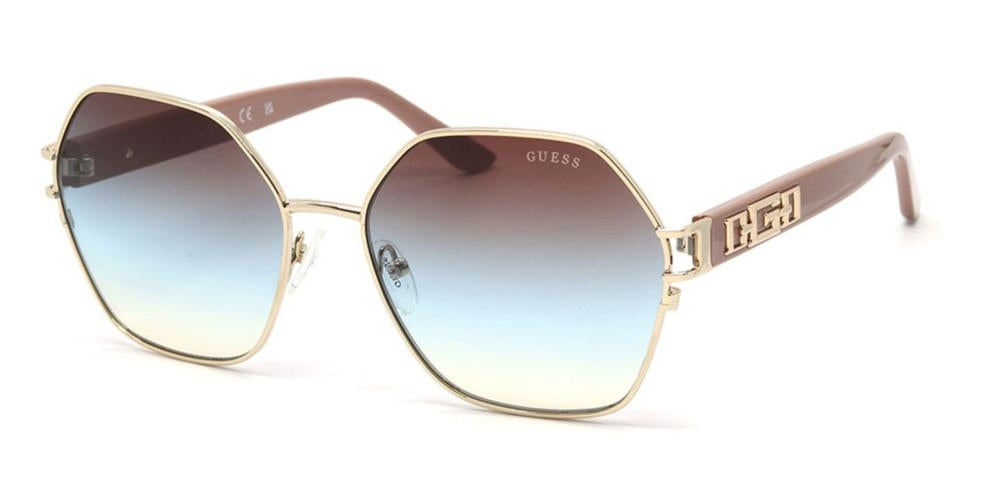 Gold geometric sunglasses with blue-to-brown gradient lenses and decorative gold temple accents on a neutral background