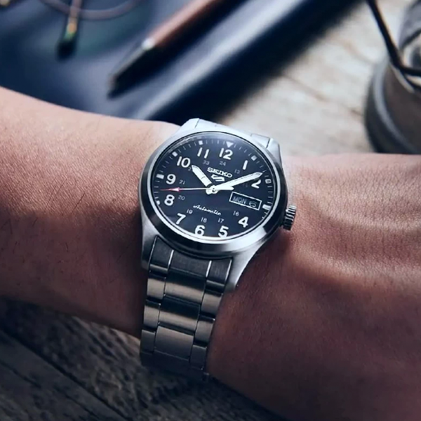 Silver stainless steel automatic wristwatch with black dial, luminous markers, and rotating bezel on bracelet